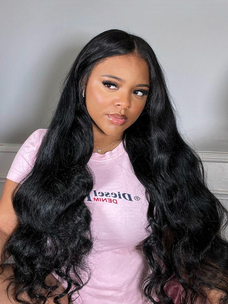 A model displays the UNice 4Pcs Brazilian Hair Body Wave Bundles With Transparent Lace Closure, showing a model with long black hair wearing a pink shirt and body wave.