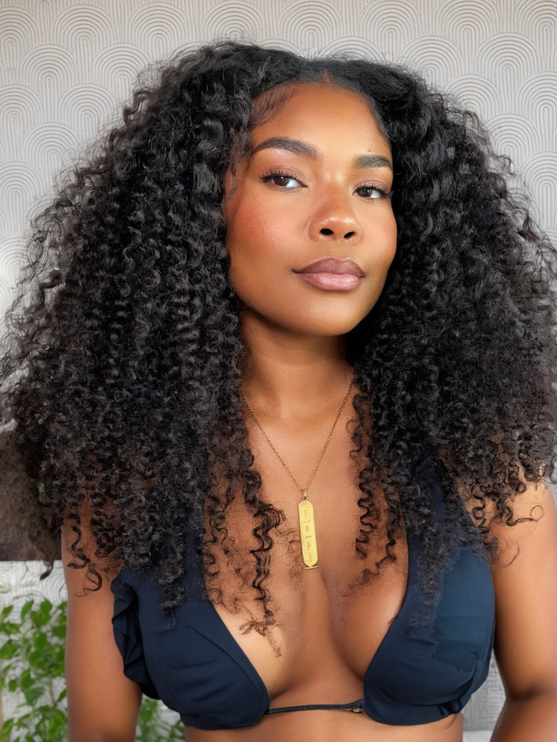 A model displays the UNice 200% Density Glueless V Part 0 Skill Needed Wig Beginner Friendly Natural, showing a model with long curly hair wearing a black bikini top.