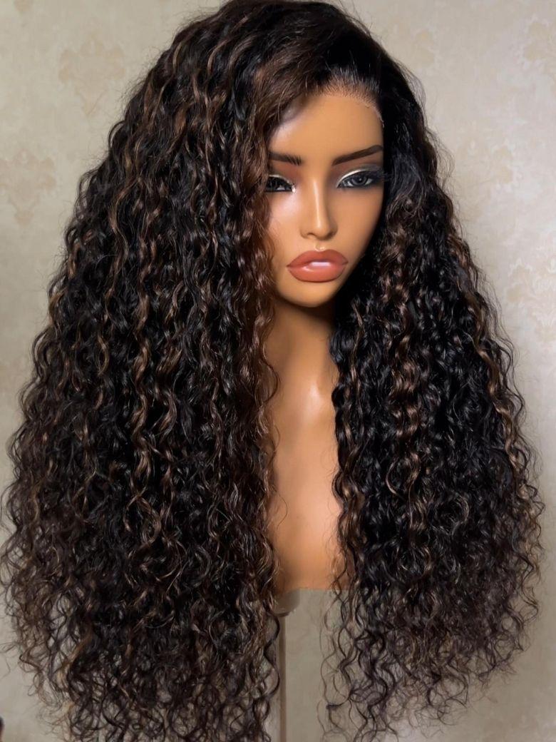 A model displays the UNice Bye Bye Slip 7x5 Lace Warm Brown with Beige Blonde Ribbon Highlights Layered wig, showing a model with blonde hair and a black top sitting.