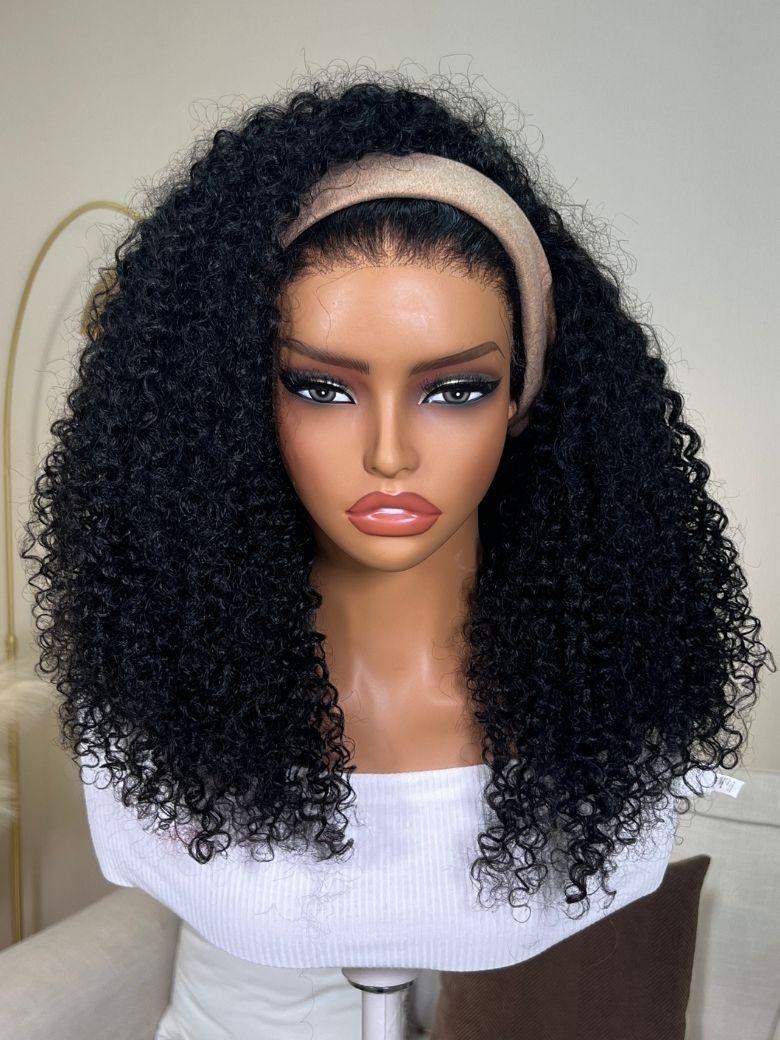 A model displays the UNice InvisiBlend V Part Curly Texture Drawstring Human Hair Wig With Finger Coil Ends, showing a model with long curly hair and brown shirt.