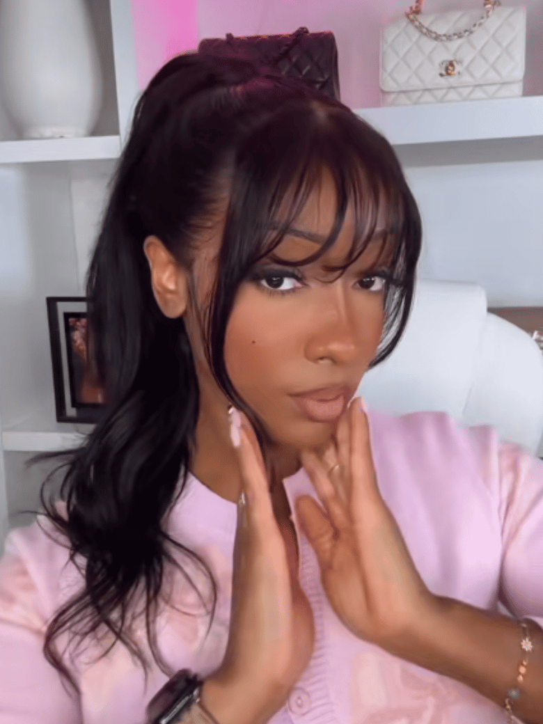 A model displays the UNice 13x4 Pre-Everything Lace Frontal Fluffy Layer Natural Loose Wave Wig With Air, showing a woman in a pink sweater is making a face and loose.
