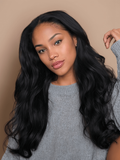 A model displays the UNice Hair 5x5 HD Lace Closure With 4 Bundles Body Wave Human Hair Weaves, showing a model with long black hair wearing a grey sweater and body wave.
