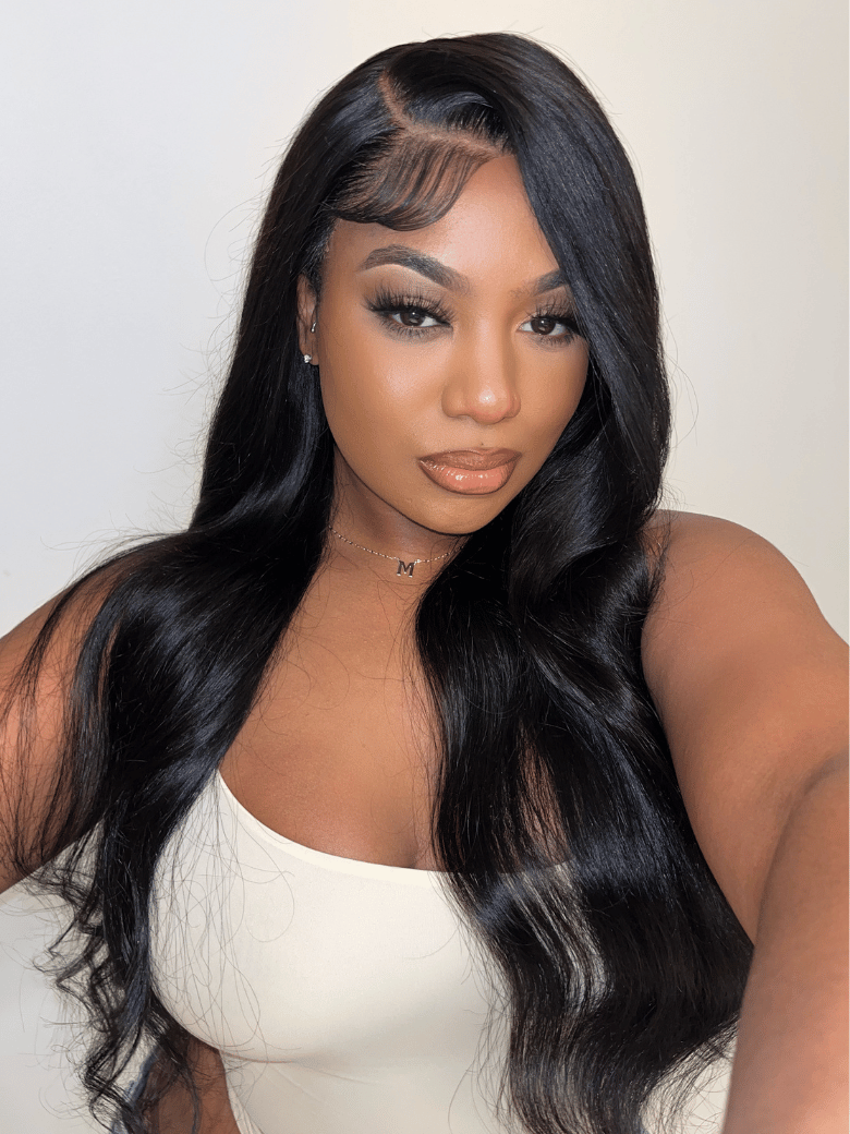 A model displays the UNice 7x5 Lace Bye Bye Knots & 13x6 Lace Frontal Black Body Wave Pre-Everything Wig, showing a model with long black hair wearing a white top.