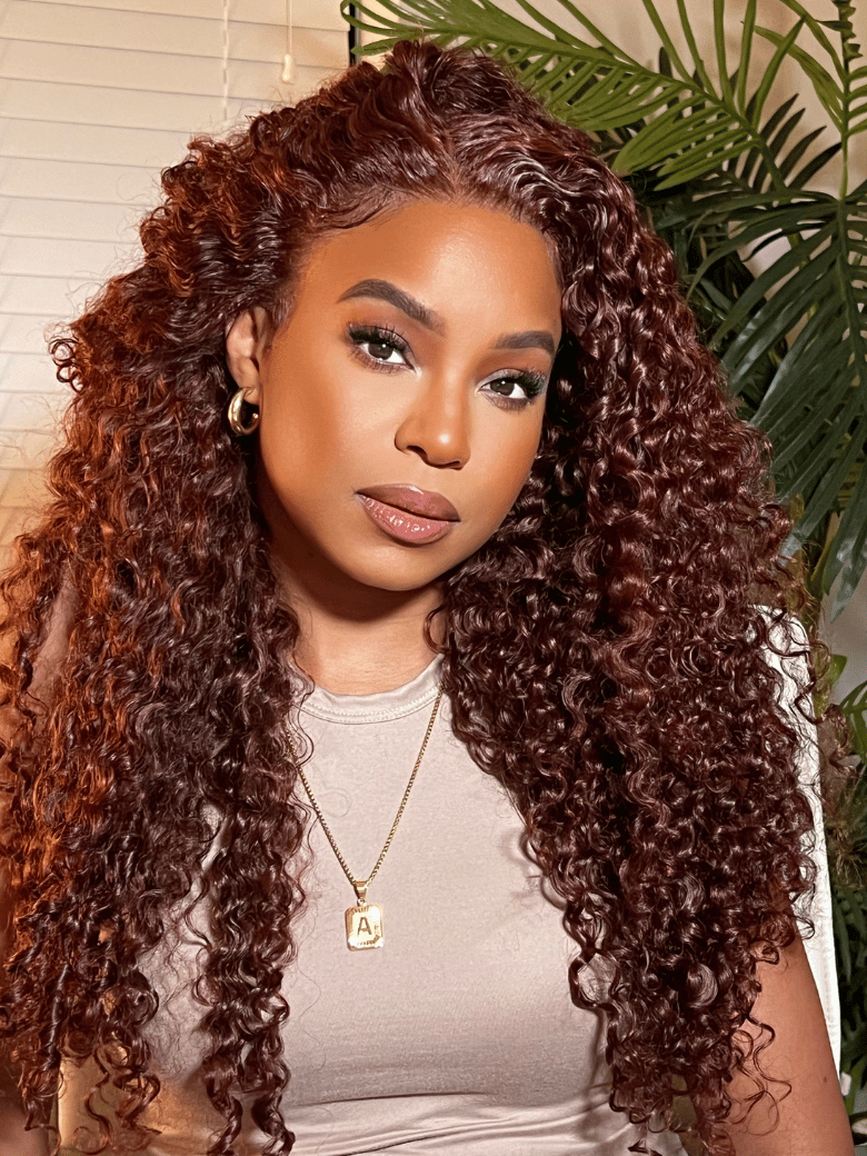 A model displays the UNice 7x5 Bye Bye Knots Wig Glueless Lace Sunset Jerry Curly for Reddish Brown, showing a model with long curly hair and a white shirt and jerry.