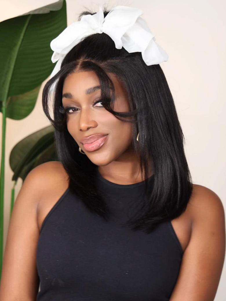 A model displays the UNice 13x4 Lace Front Yaki Bob Wig With Invisible Drawstring Pre-Cut, Pre-Bleached &, showing a model with a white bow on her head and yaki texture.
