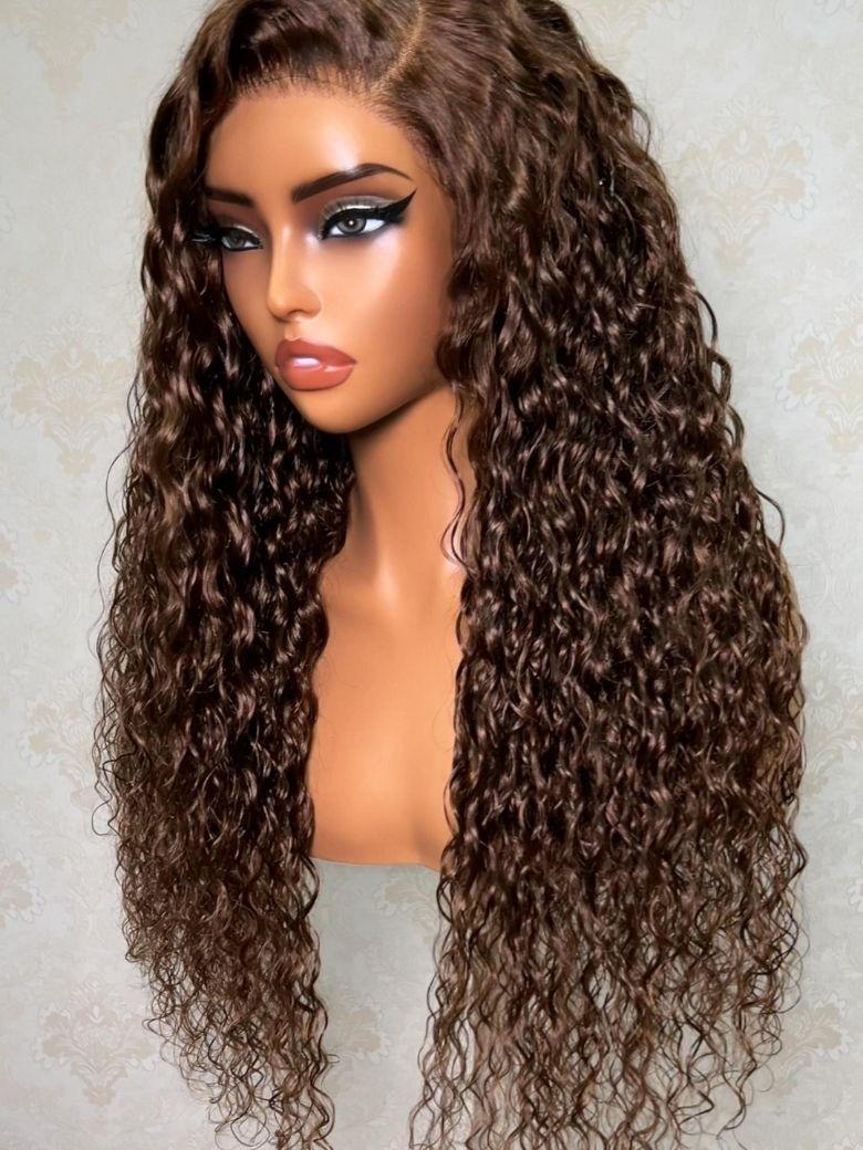 A model displays the UNice 7x5 Bye Bye Slip Lace Ash Brown With Dark Roots Curly Glueless Wig with Invisi, showing a model with long curly hair and glasses holding.