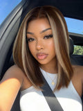 A model displays the UNice 7x5 Bye Bye Slip Lace Glueless Brown with Blonde Skunk Stripe Straight Bob Wig, showing a model with long brown hair and a white top sitting.