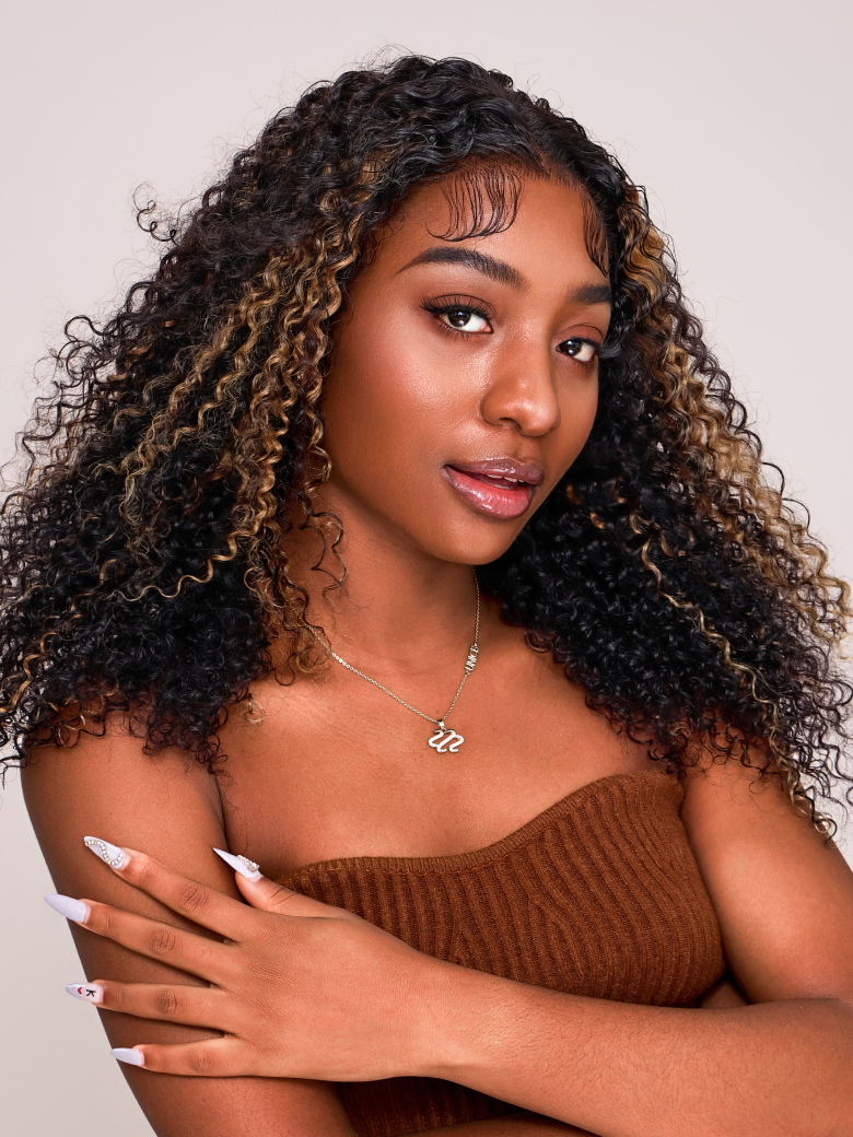 A model displays the UNice 6x4.5 Pre Cut Lace Curly Wig Put On And Go Quick Easy Black With Blonde Highlights, showing a model with curly hair and curly texture.